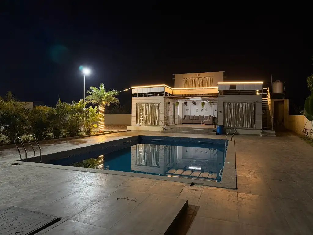 Pool lit up at night at Marvel Farm Stay, Moinabad