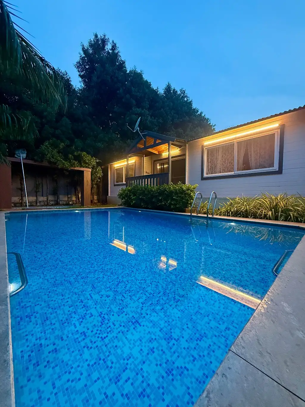 Pool lit up at night at wooden escape, Tolkatta, Moinabad