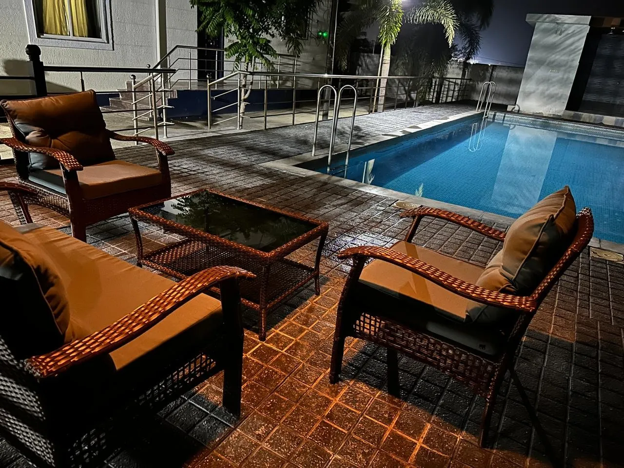 Pool lit up at night at The Orchids FarmHouse, Moinabad